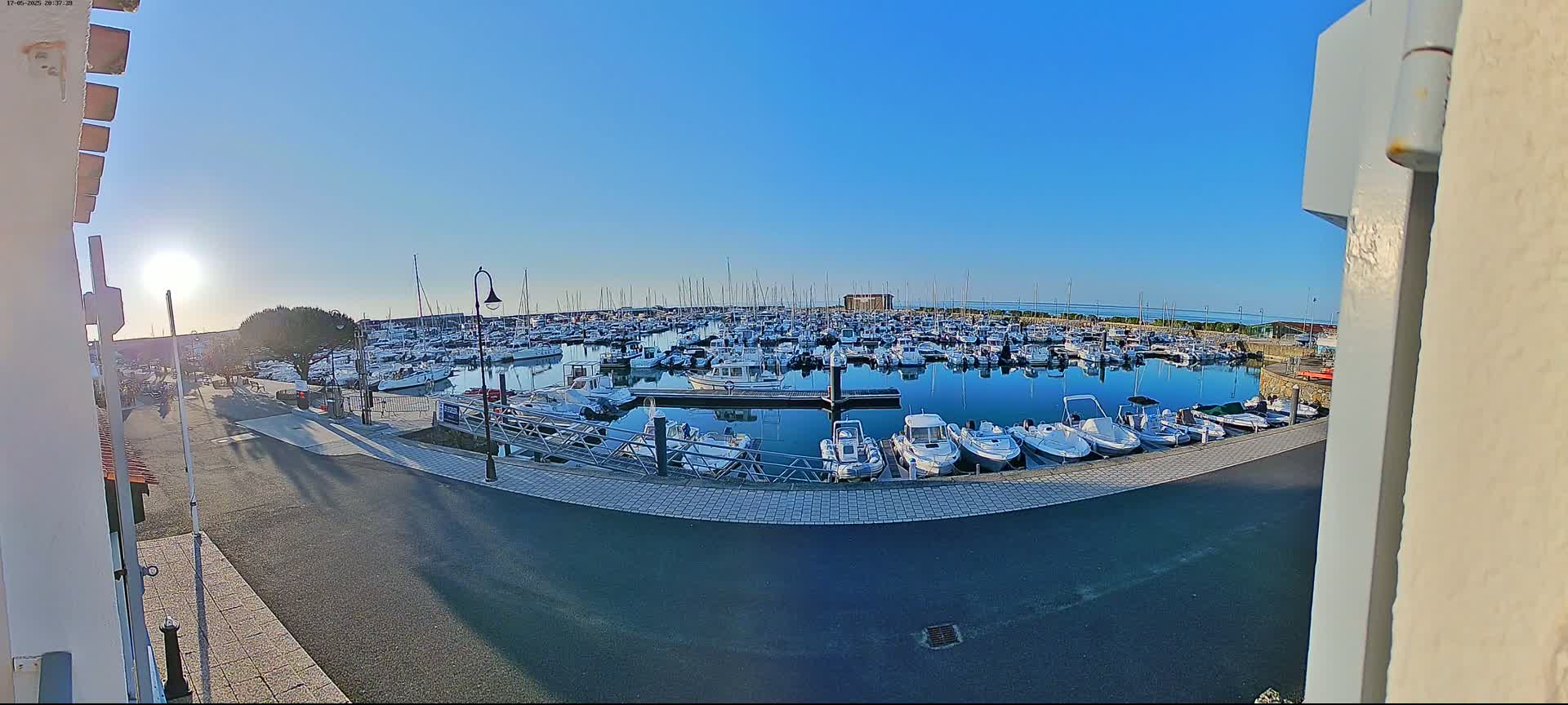 A marina filled with numerous boats is seen on a sunny day.