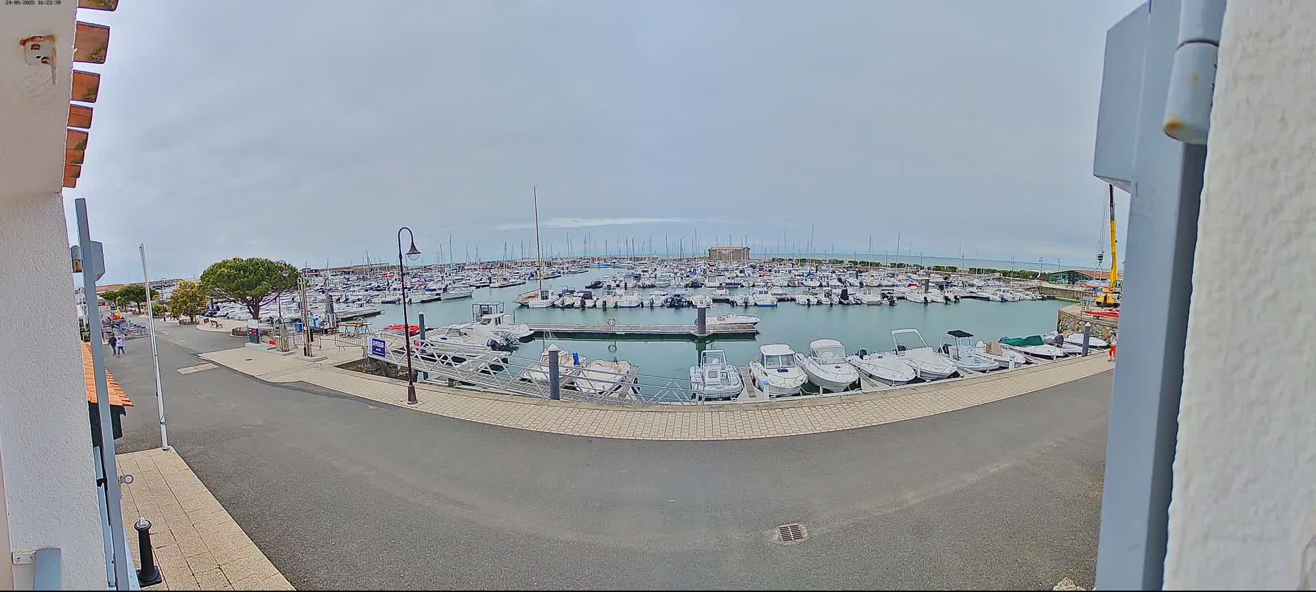 A marina filled with numerous boats is seen on an overcast day.