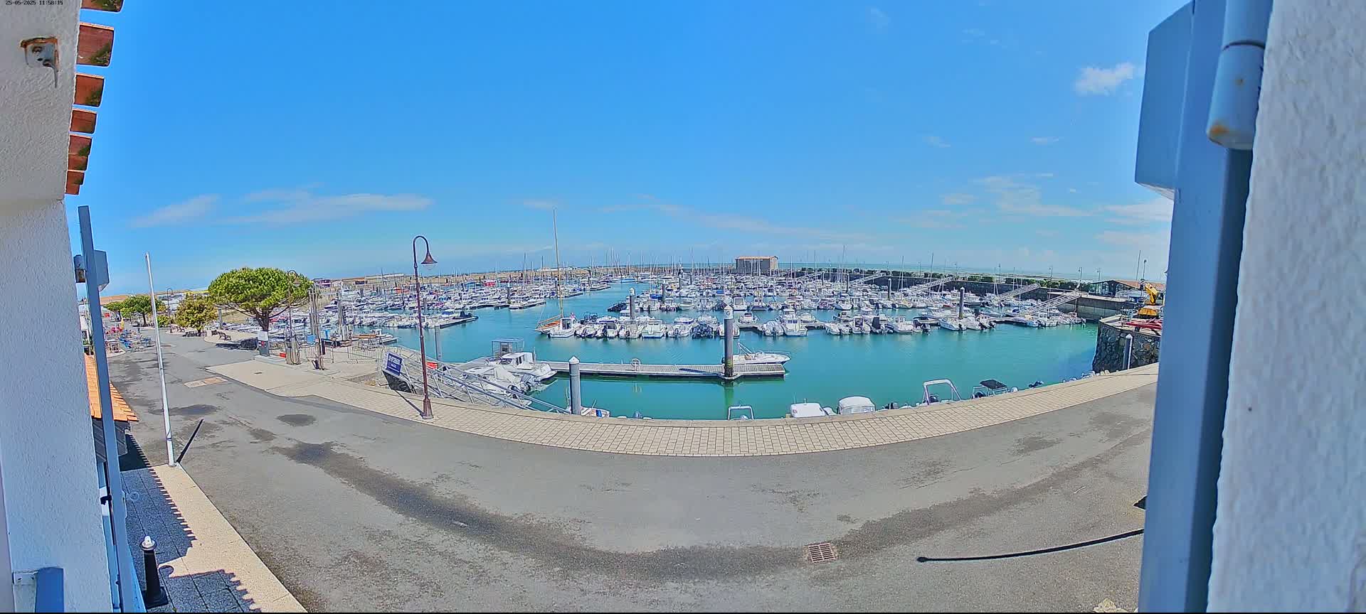 A marina filled with numerous boats is seen on a sunny day.