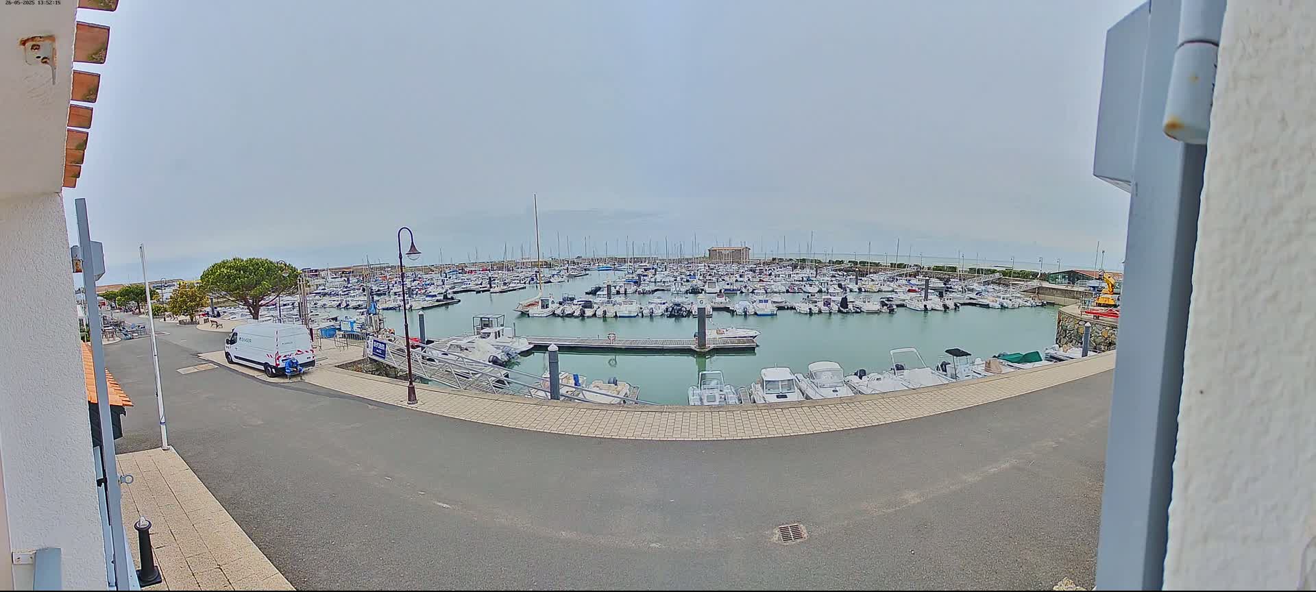 A marina filled with numerous boats is seen on an overcast day.