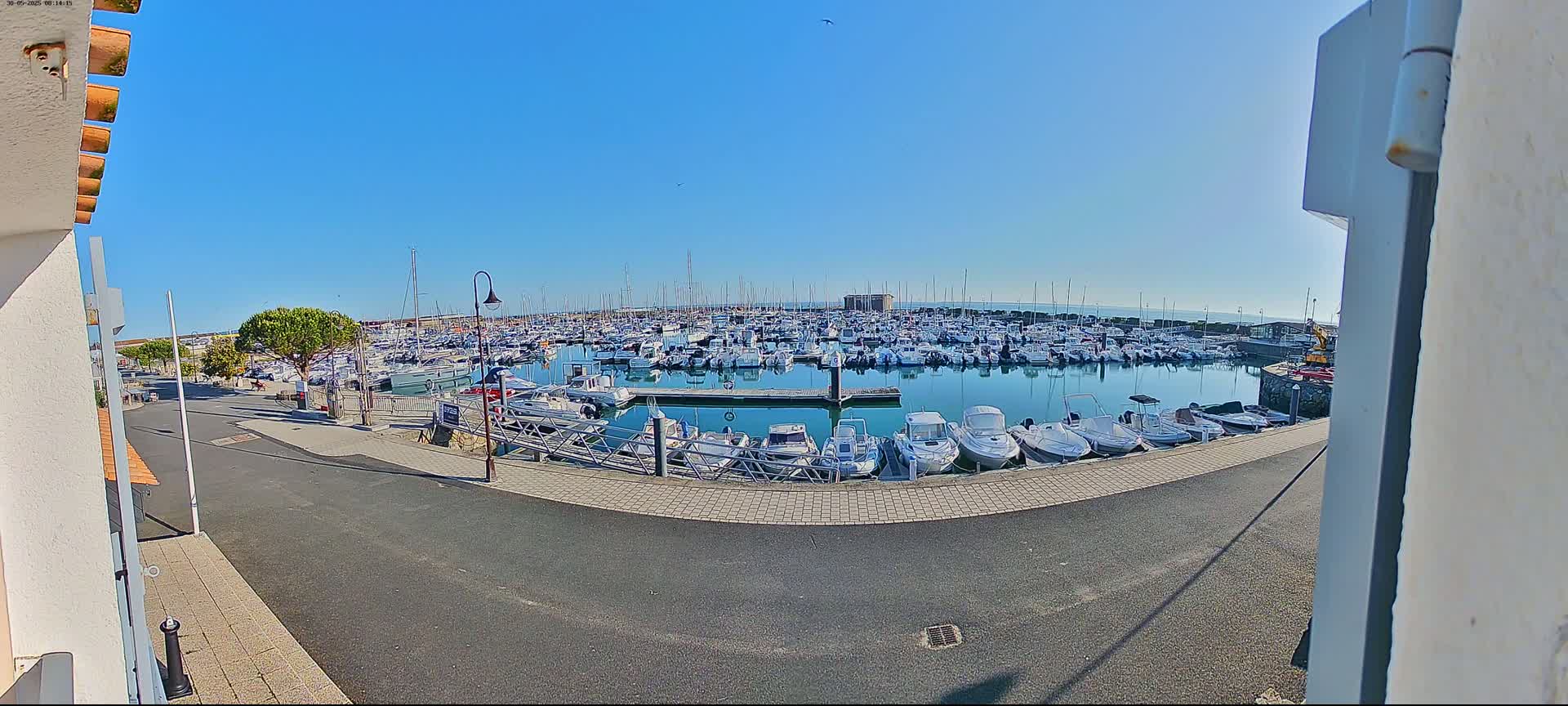 A marina filled with numerous boats is seen on a sunny day.