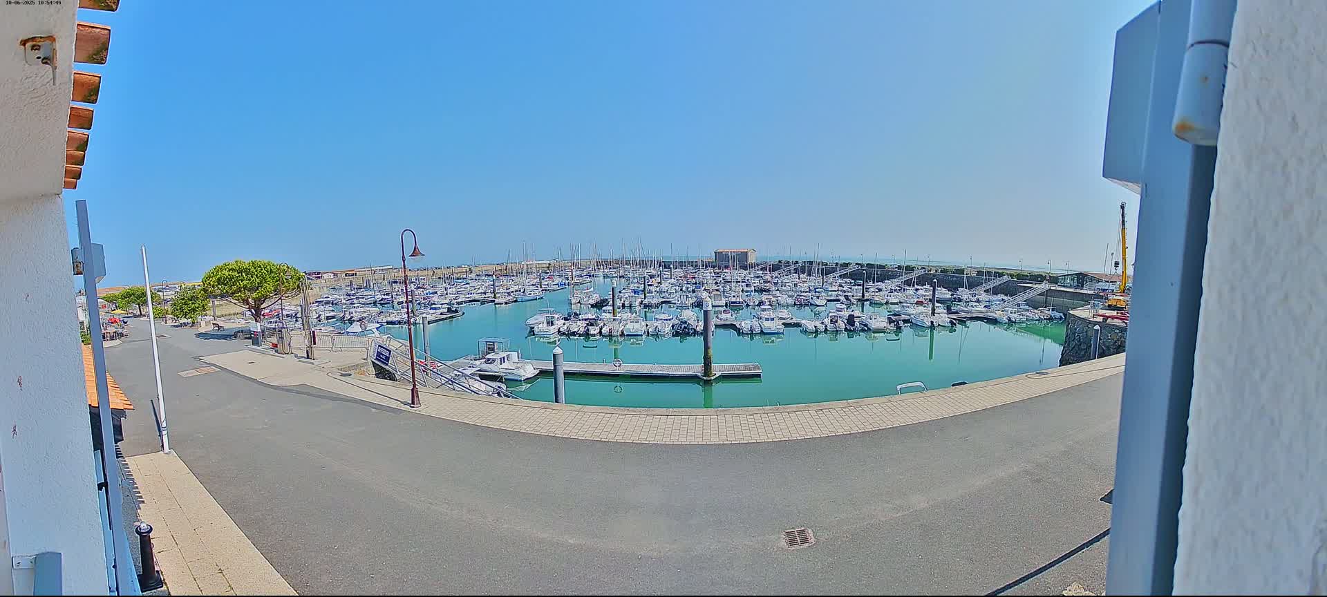 A marina filled with numerous boats is seen on a sunny day.