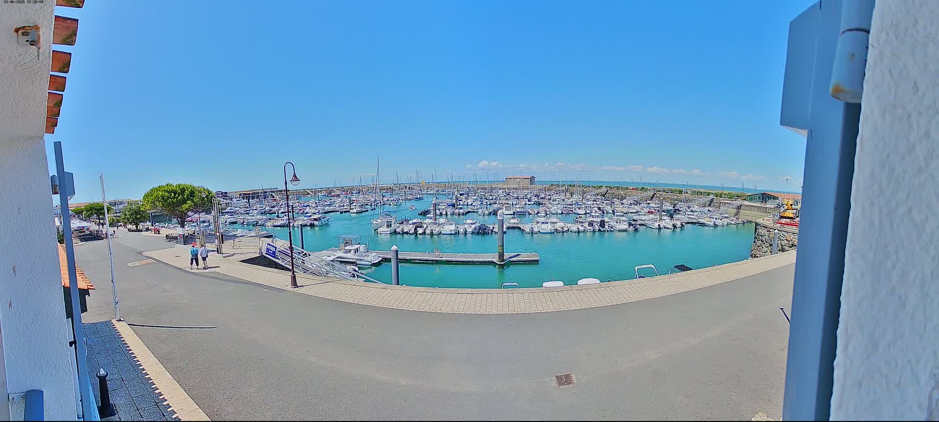 A marina filled with numerous boats is seen on a sunny day.