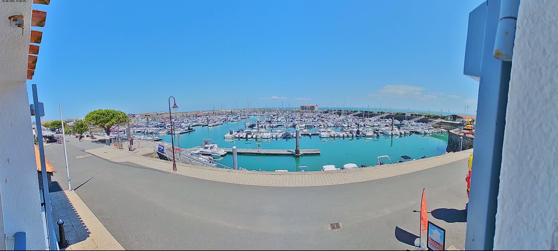 A marina filled with numerous boats is seen on a sunny day.