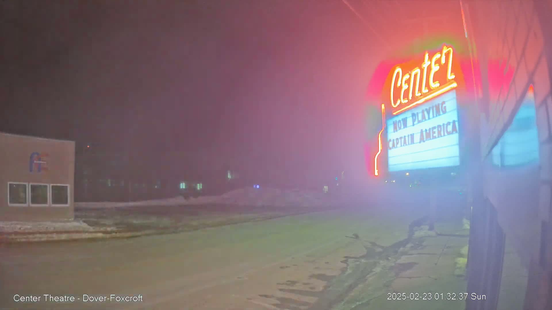 A movie theater marquee advertising Captain America in foggy nighttime conditions.