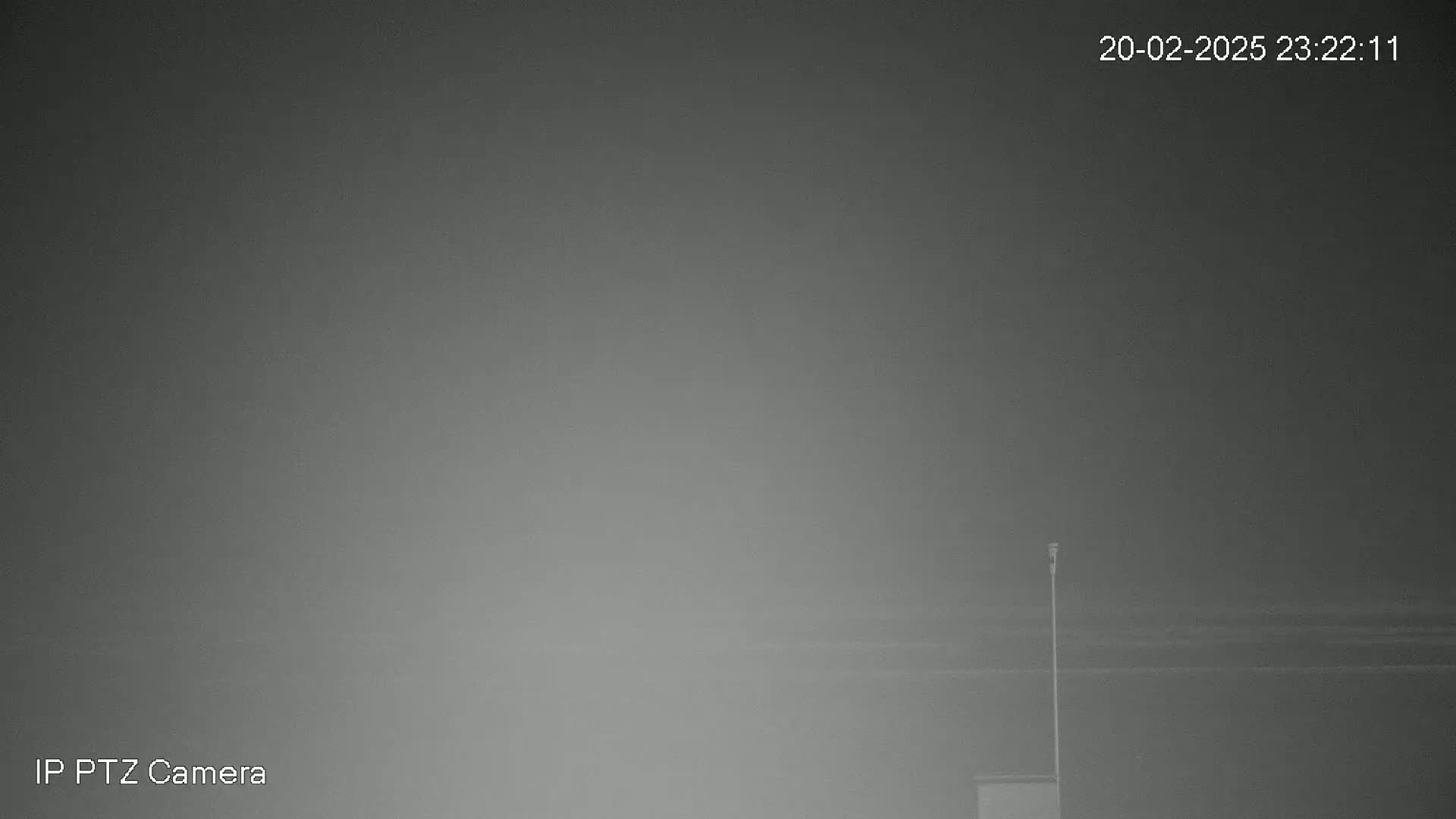 A nighttime, foggy scene shows a tall, thin pole and a small structure in the bottom right corner.