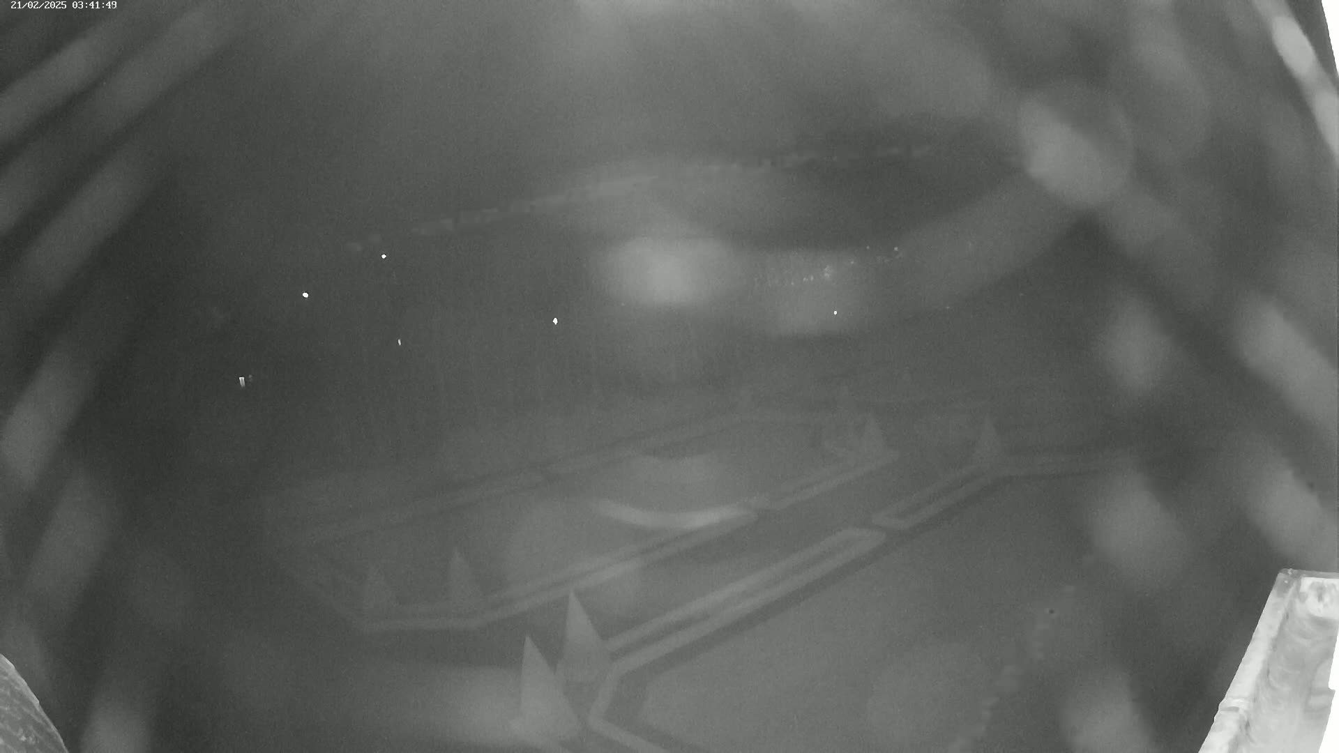 A nighttime, blurry, low-light view of a geometrically patterned garden or park.