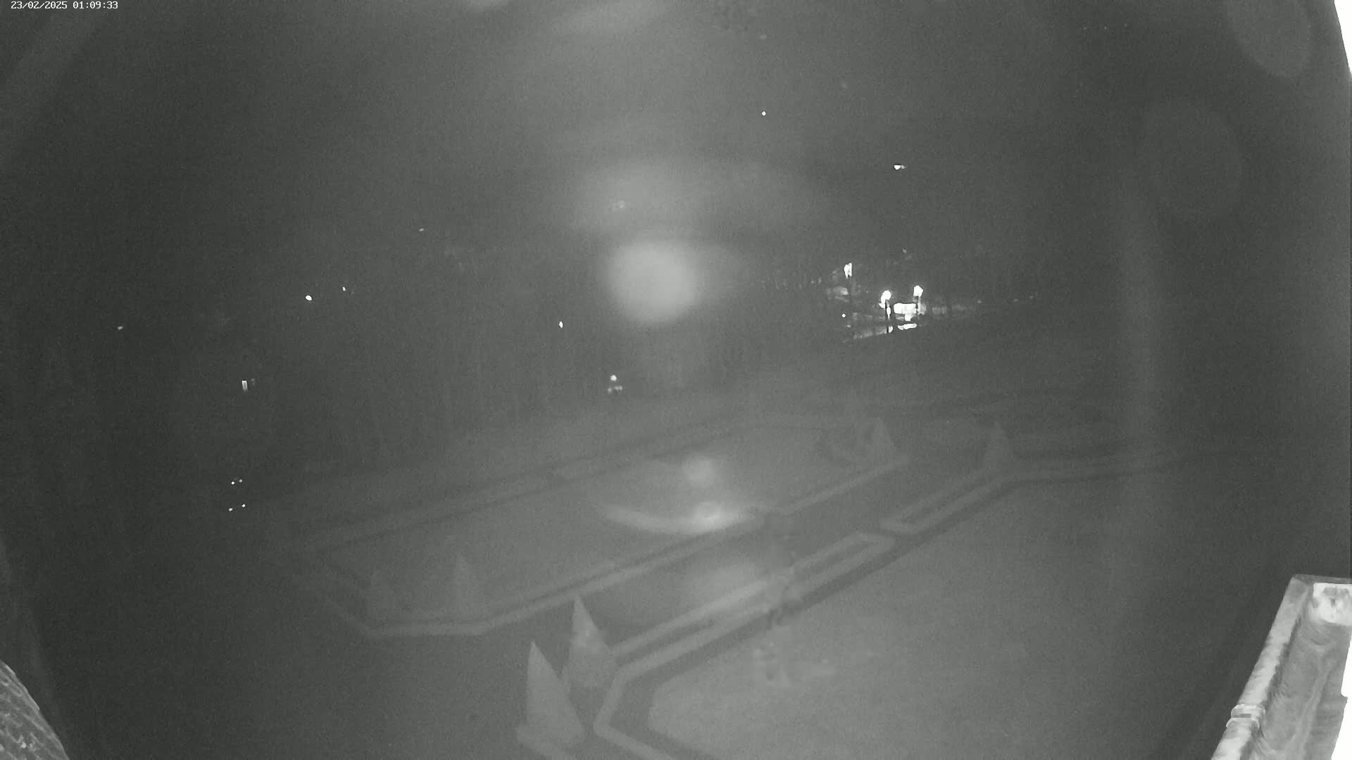A nighttime, low-light view of an empty, geometrically patterned outdoor area.