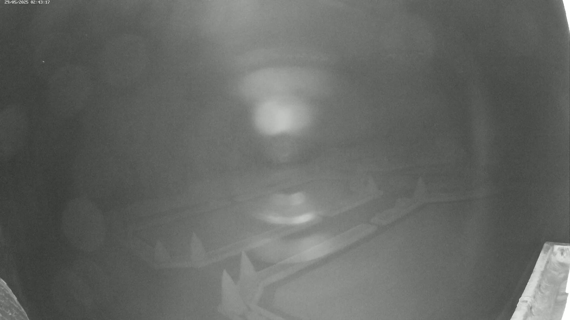 A blurry, low-light image shows several indistinct objects, possibly metallic, lying on a dark surface.