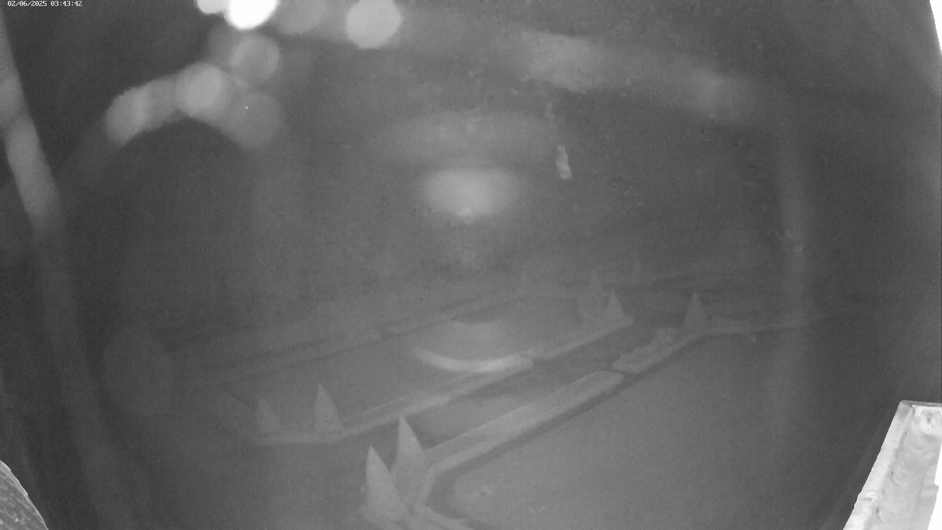 A nighttime, low-light image shows several indistinct, dark objects that appear to be long and rectangular, possibly lying on the ground.