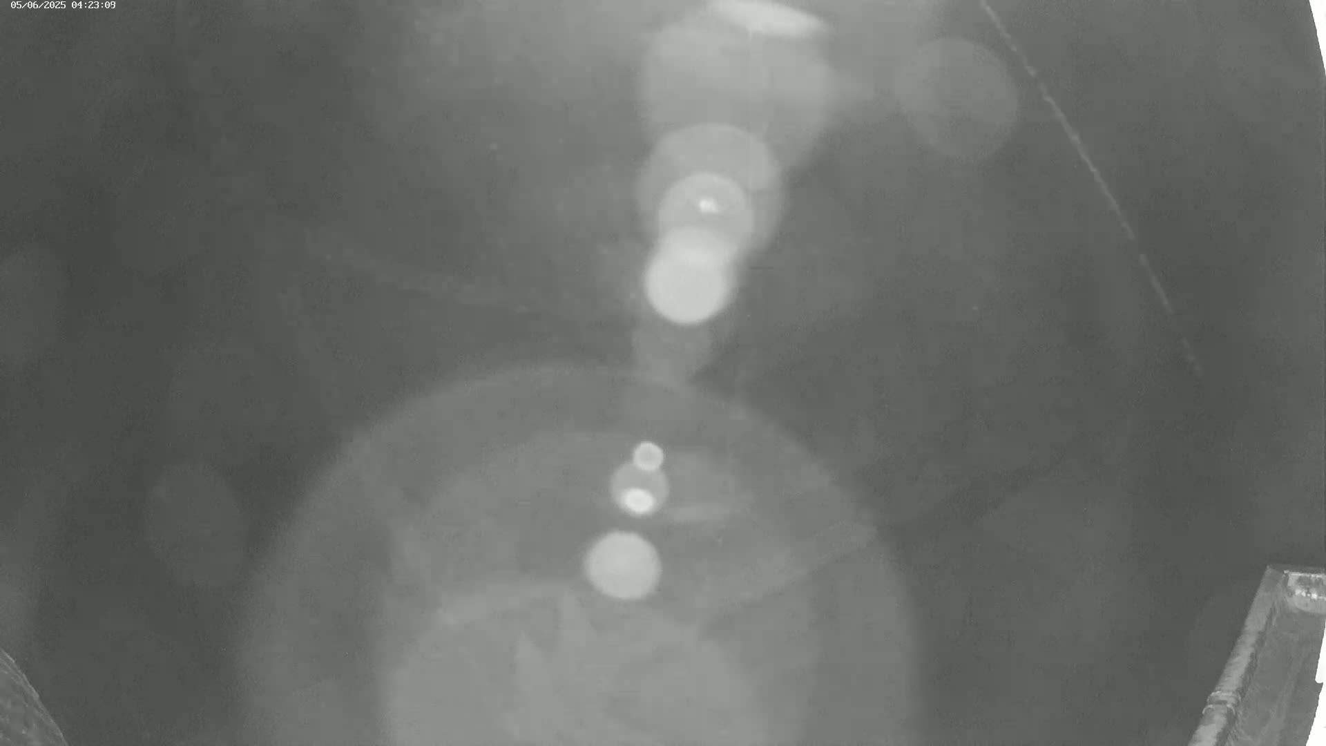 A blurry grayscale image shows an indistinct dark area with several bright, out-of-focus light sources.