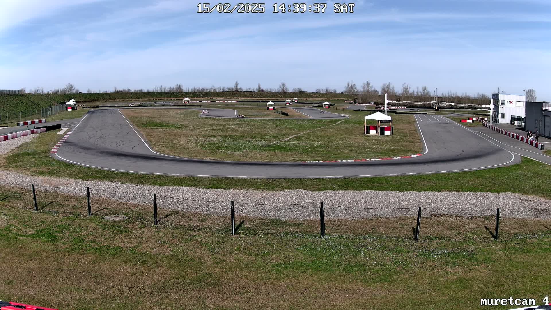 A go-kart track with several karts visible on a sunny day.