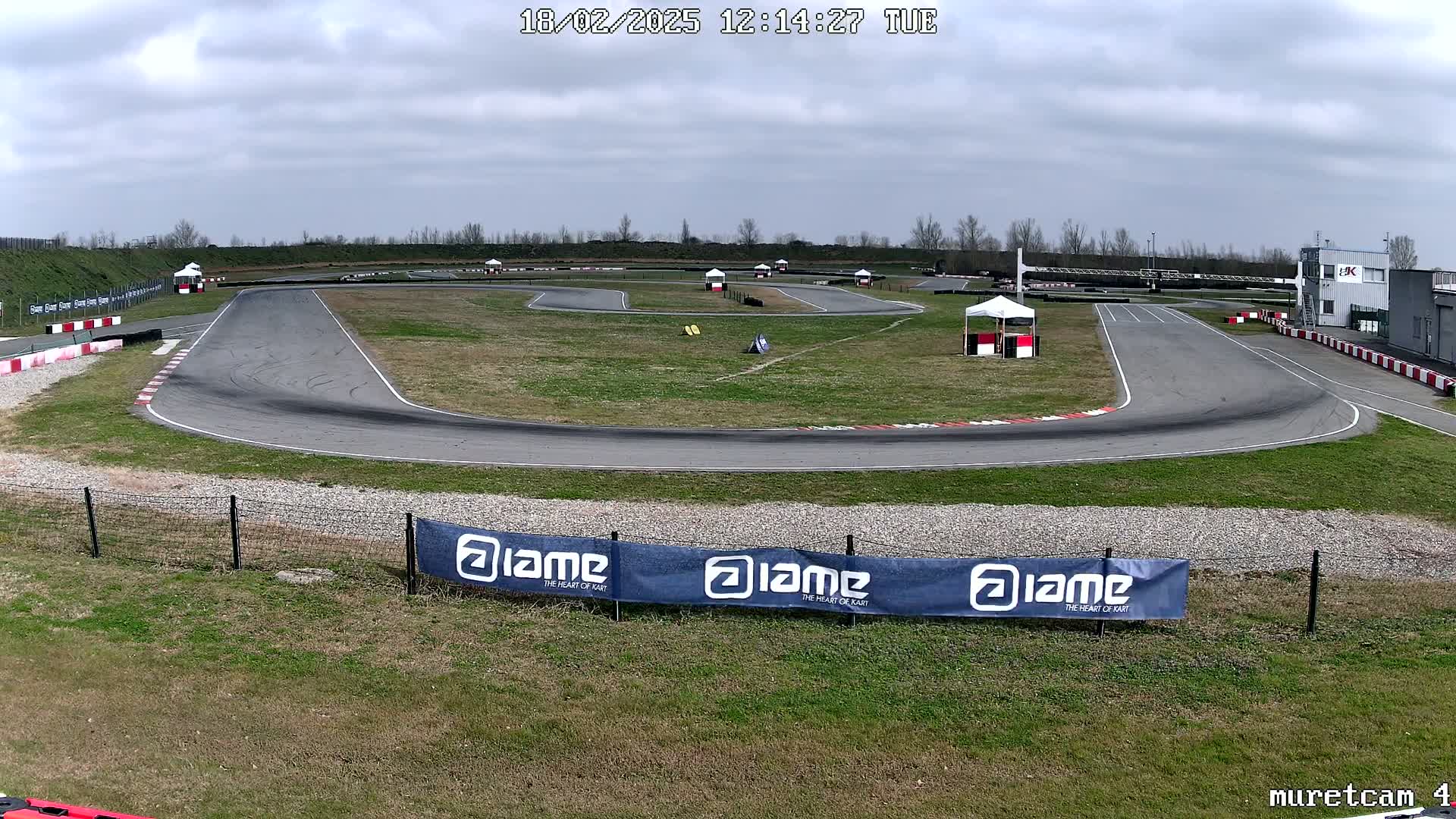 An empty go-kart track on a partly cloudy day.