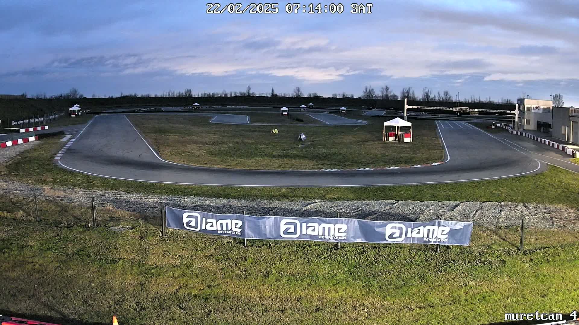 An empty go-kart track on a partly cloudy morning.