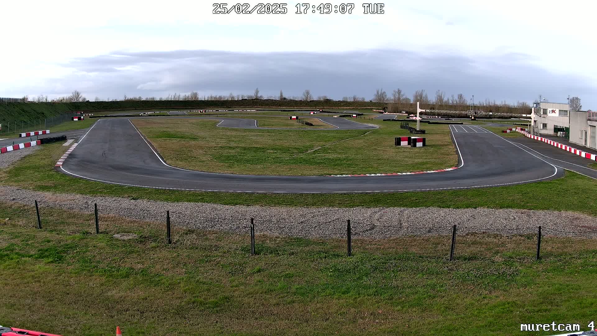 An outdoor go-kart track with overcast skies is shown.