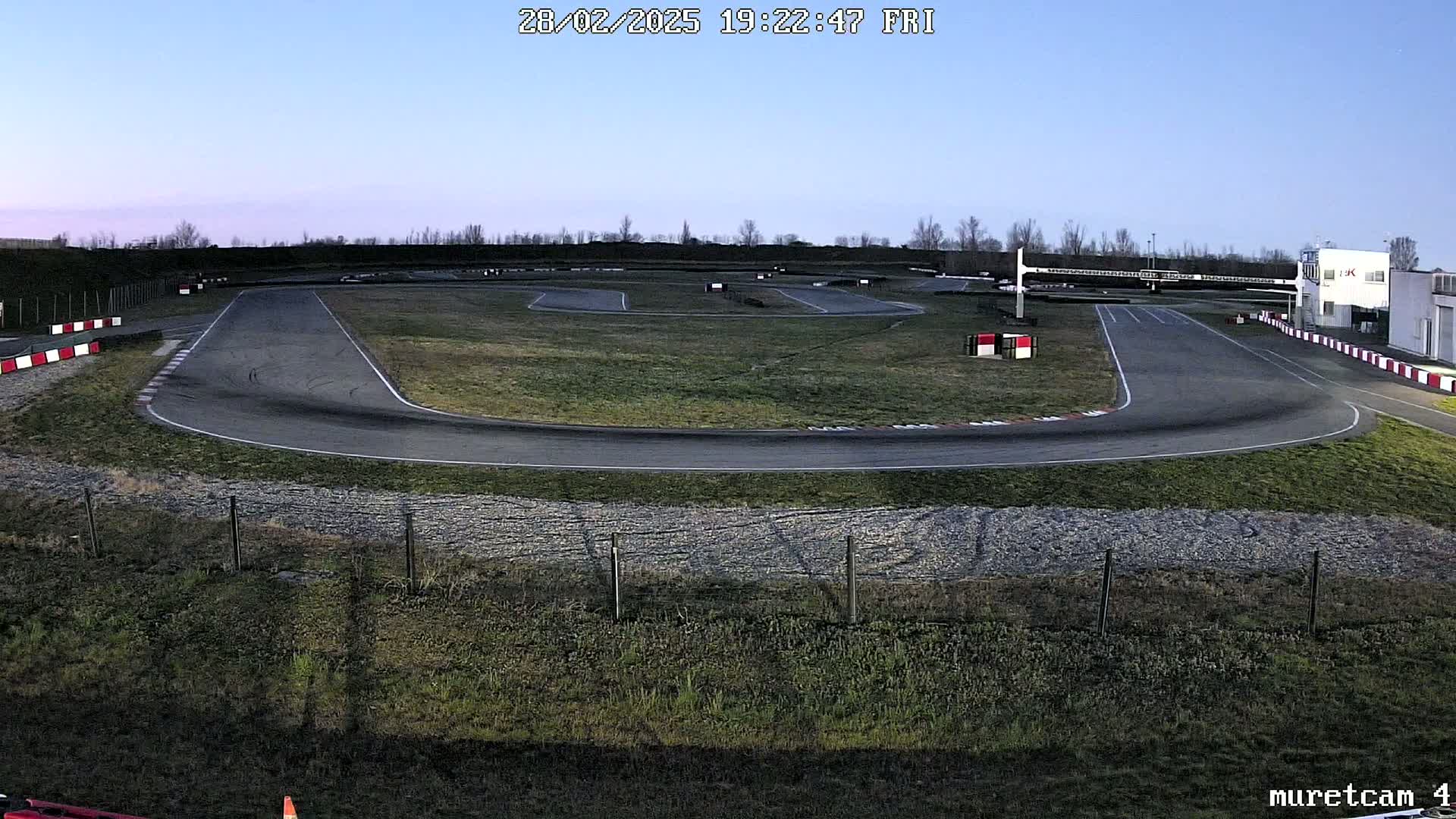 An empty go-kart track under a twilight sky.
