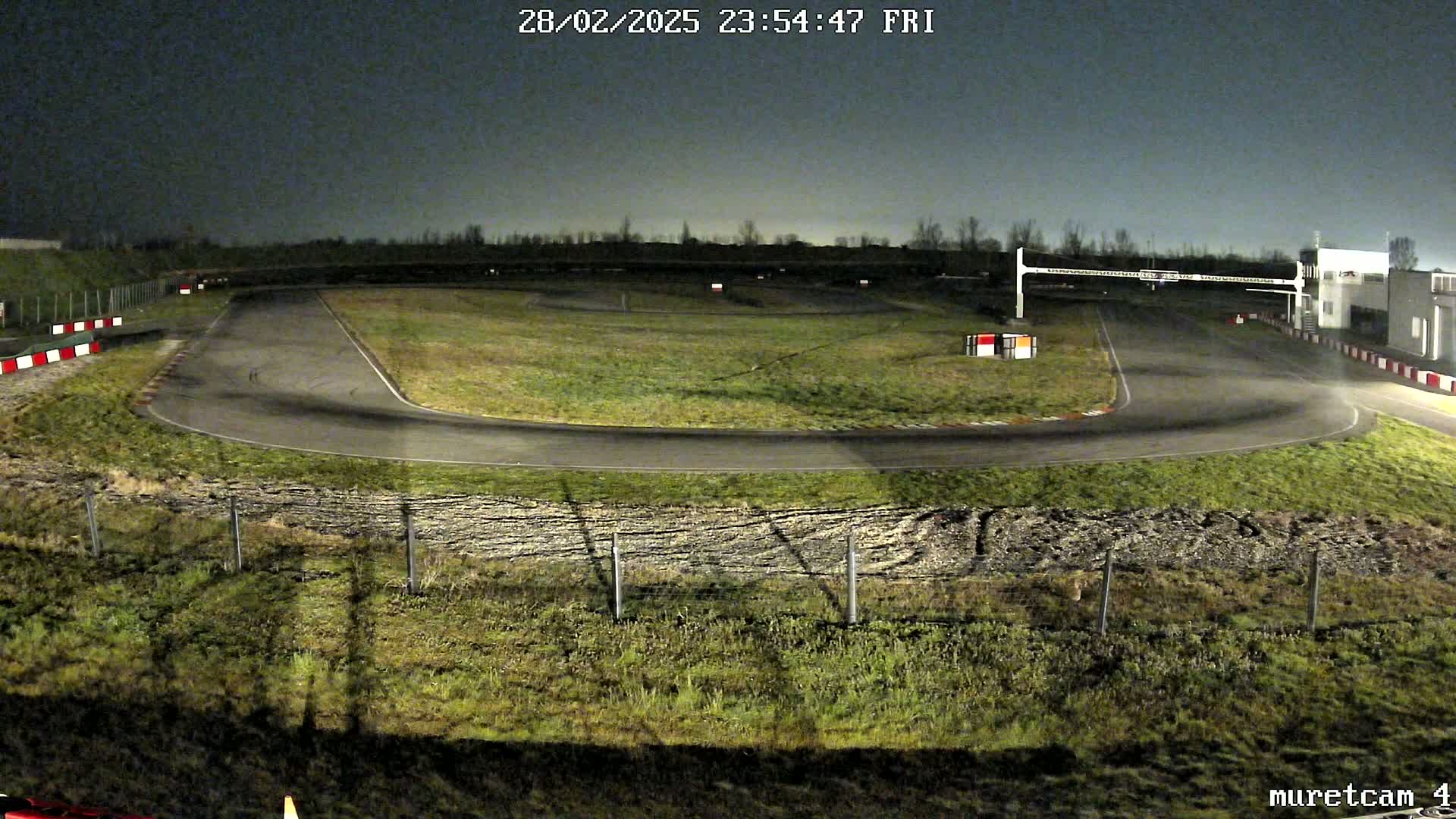 An empty go-kart track is illuminated at night.