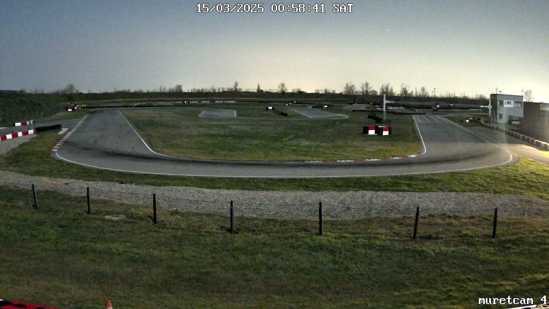 An empty go-kart track under a twilight sky.