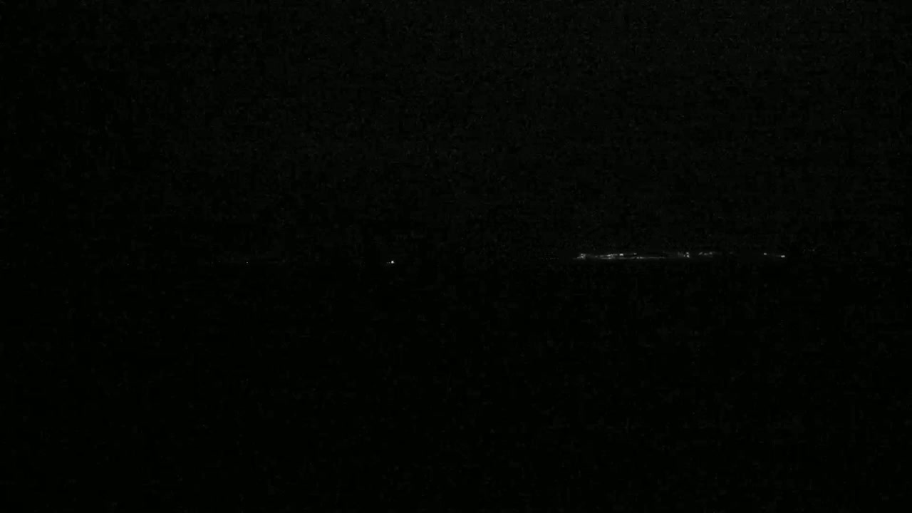 A long, faint line of lights is visible in the dark, possibly at night.