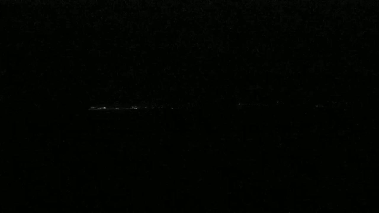 A long, faint line of lights is visible on the horizon at night.