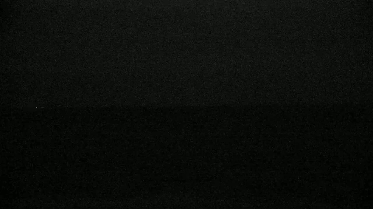The image shows a dark, grainy surface, possibly at night.