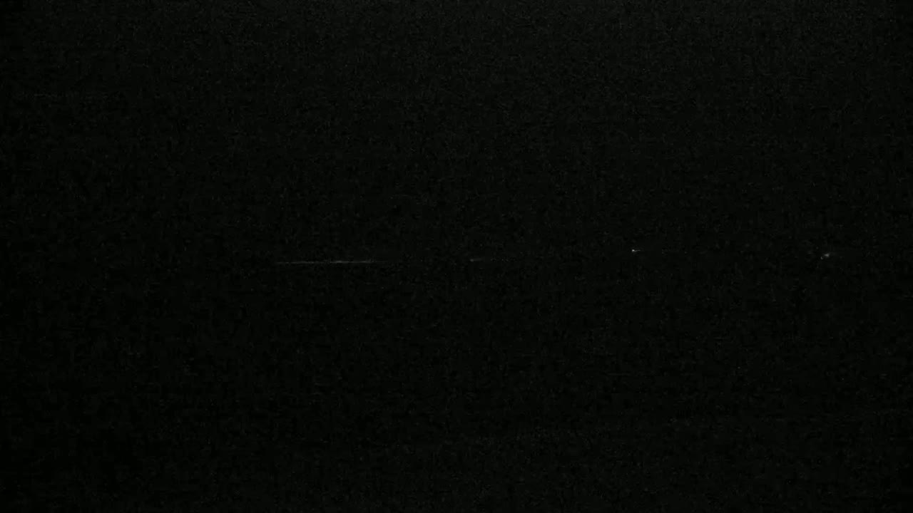 The image shows a completely black background with very faint, barely visible scratches.