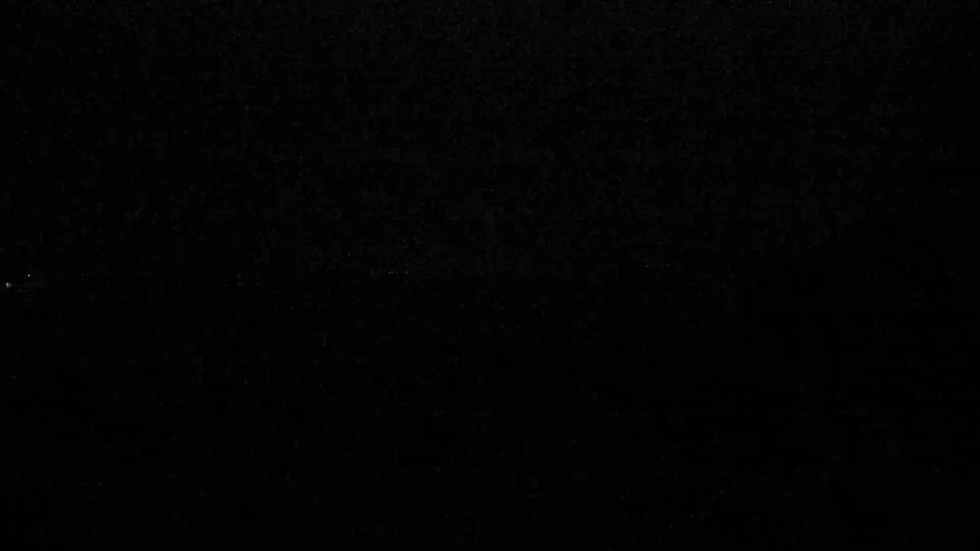 The image is a completely black field with a few barely visible specks of light.