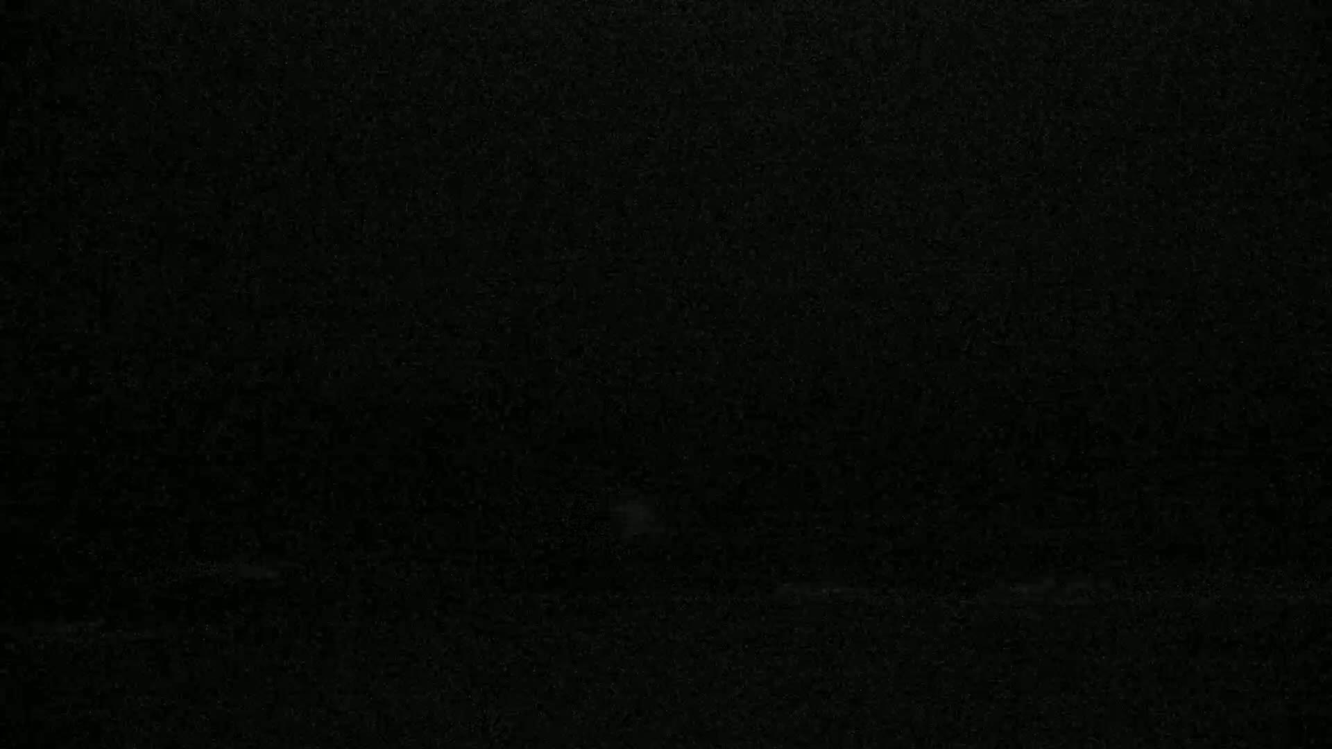 The image shows a completely dark, grainy surface.