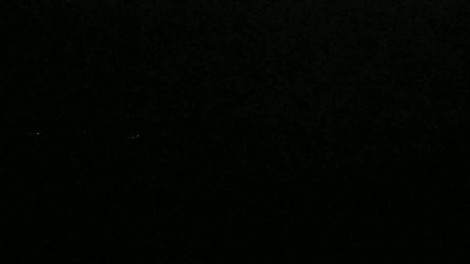 The image shows a completely black field with two tiny specks of light.