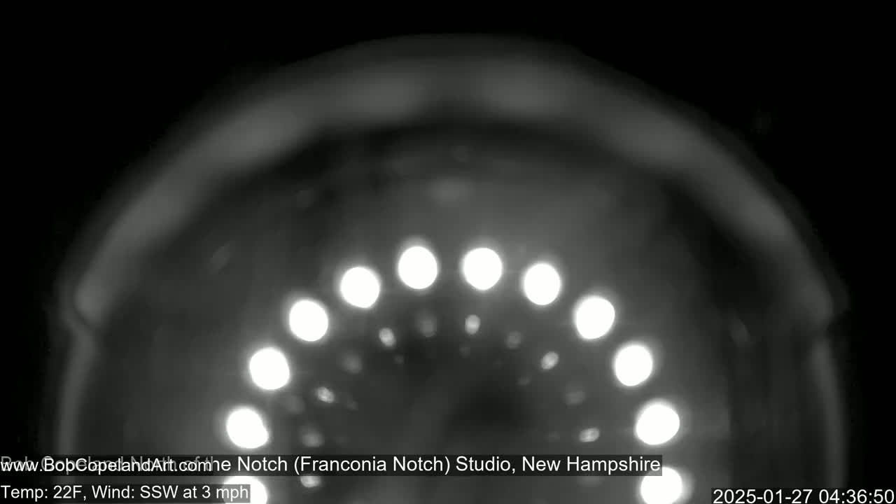 A blurry, nighttime image shows a semicircle of bright lights, with a temperature of 22°F and a south-southwesterly wind of 3 mph.