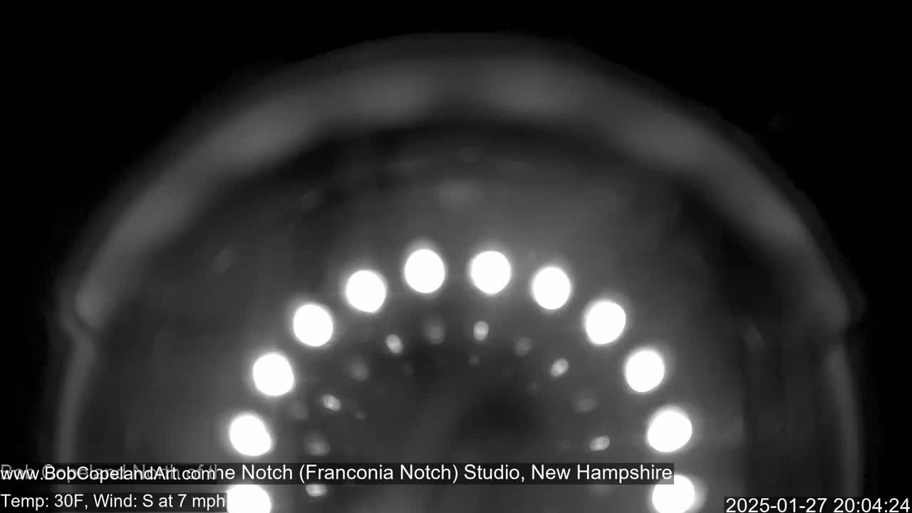 A blurry, nighttime image shows a semicircle of bright lights against a dark, possibly snowy background with a 30°F temperature and a 7 mph south wind.