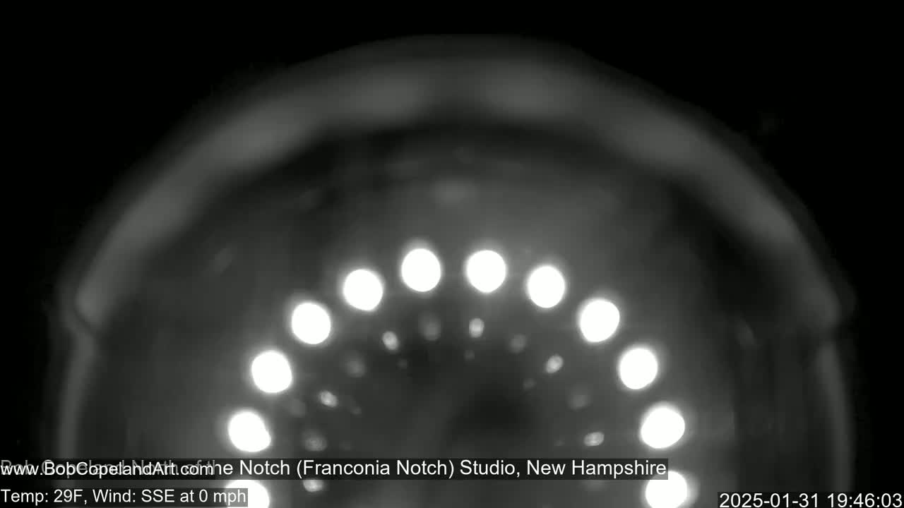 A blurry, nighttime image shows a semicircle of bright lights against a dark, out-of-focus background in calm, 29°F weather.