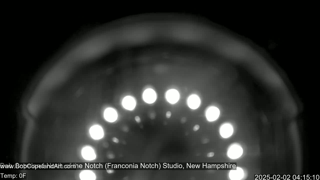 A blurry, nighttime image shows a semicircle of out-of-focus lights.