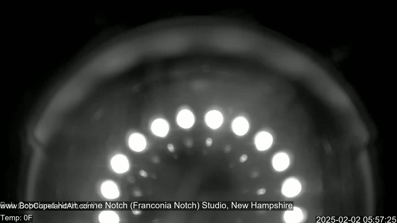 A blurry, nighttime image shows a semicircle of bright lights.