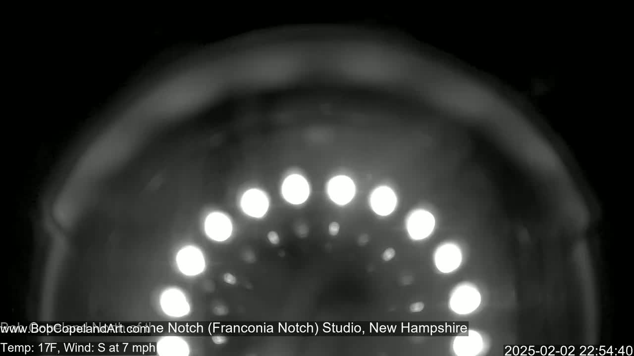 A blurry, nighttime image shows a semicircle of out-of-focus lights.