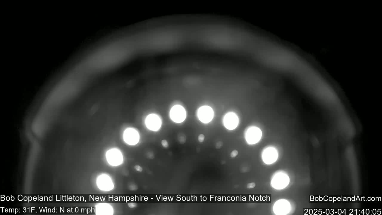 A blurry, nighttime image shows a curved line of bright lights against a dark background, in 31°F weather with no wind.