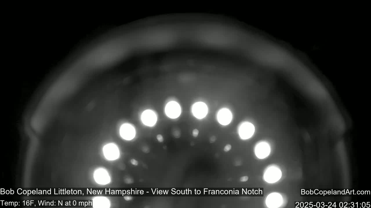 A blurry, nighttime image shows a semi-circular arrangement of bright lights against a dark background, with a temperature of 16°F and no wind.