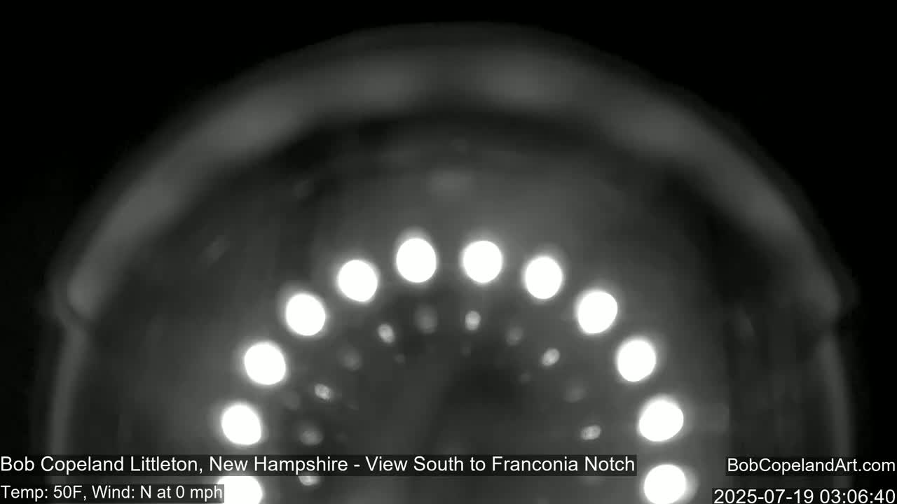 A blurred, nighttime image shows a semi-circular arrangement of bright lights.