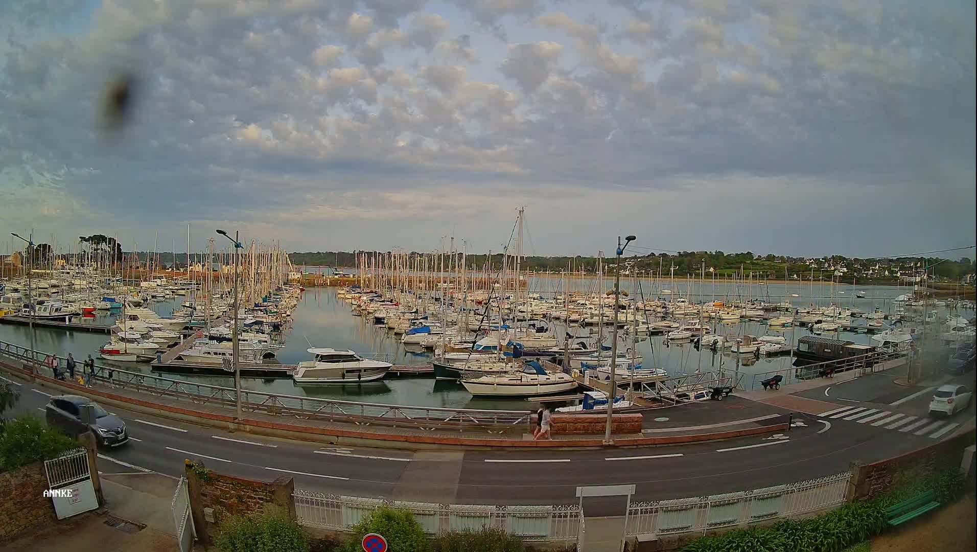 A large marina filled with sailboats and motorboats under a partly cloudy sky.