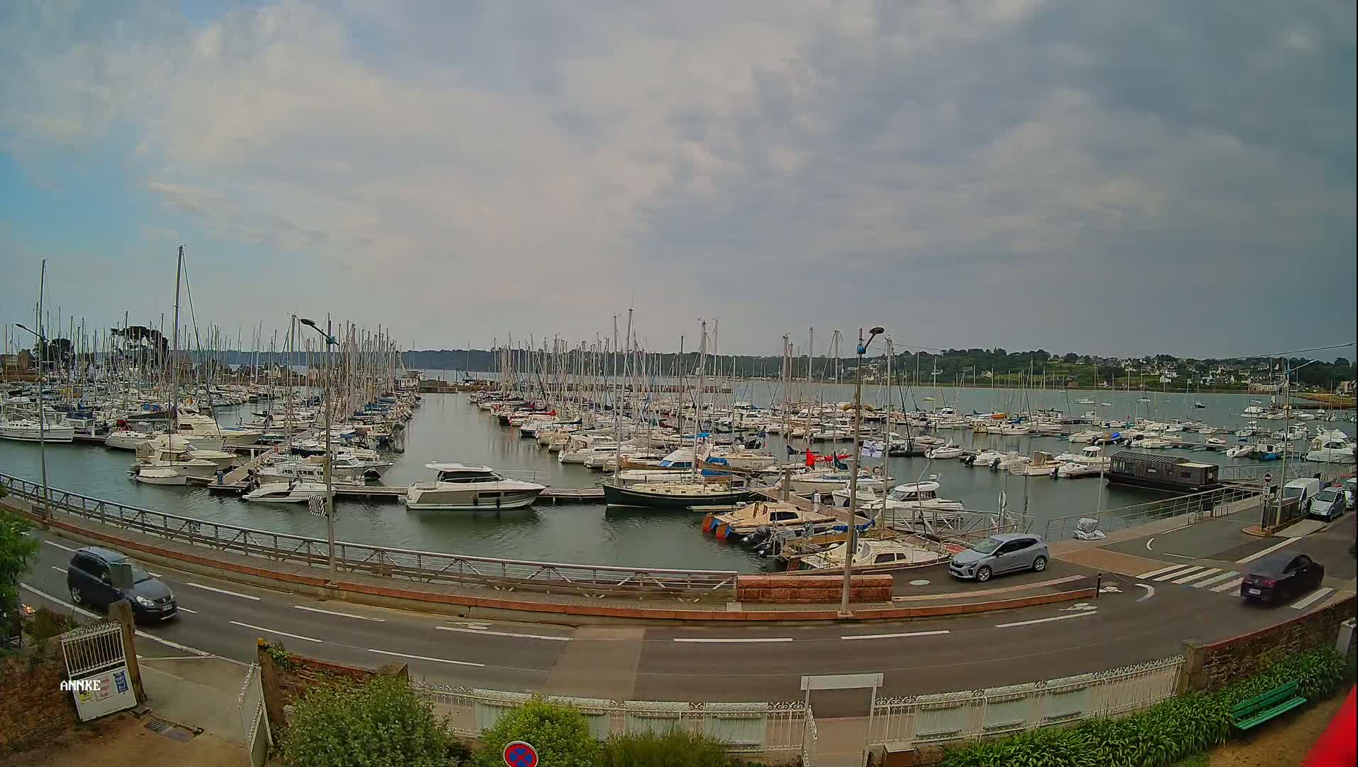A harbor filled with numerous sailboats and motorboats under a cloudy sky.