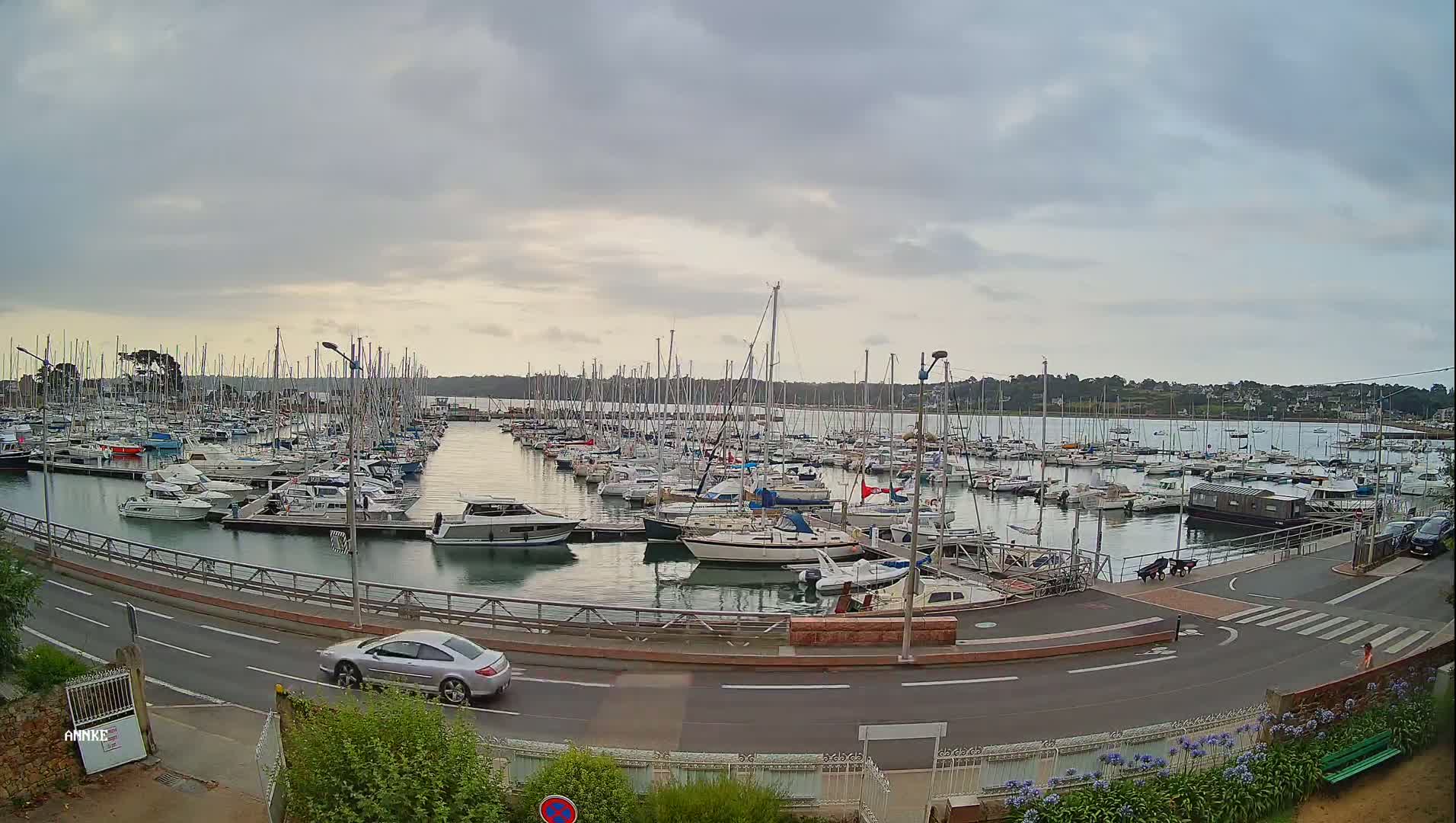 A large marina filled with sailboats and motorboats under a cloudy sky.