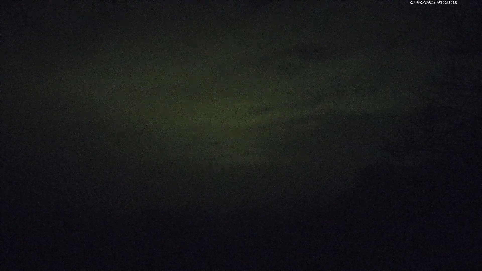 A dark, mostly black image with subtle variations in shading, possibly depicting a nighttime sky.