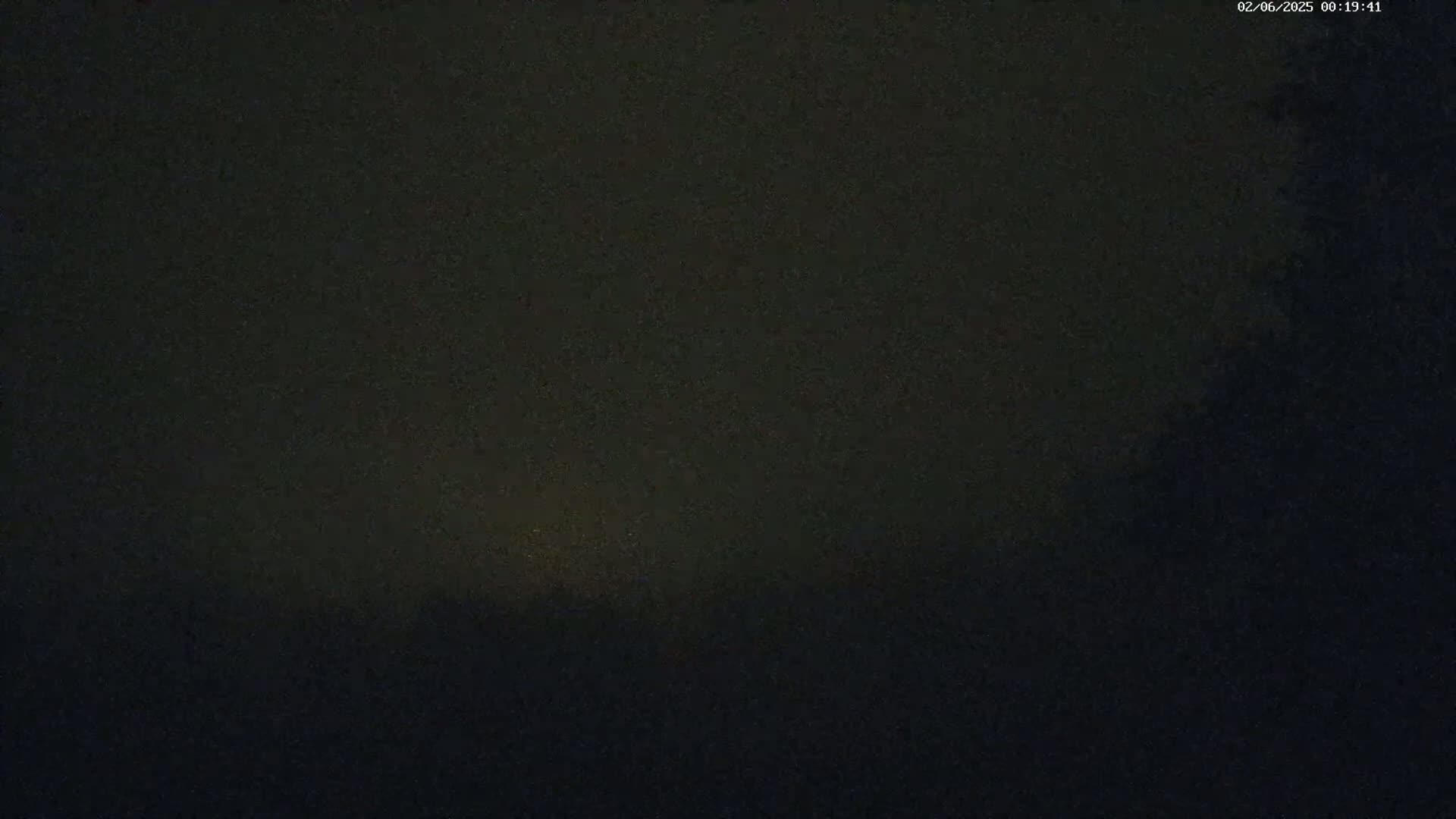A dark, possibly nighttime, scene with a faint, yellowish glow near the horizon.