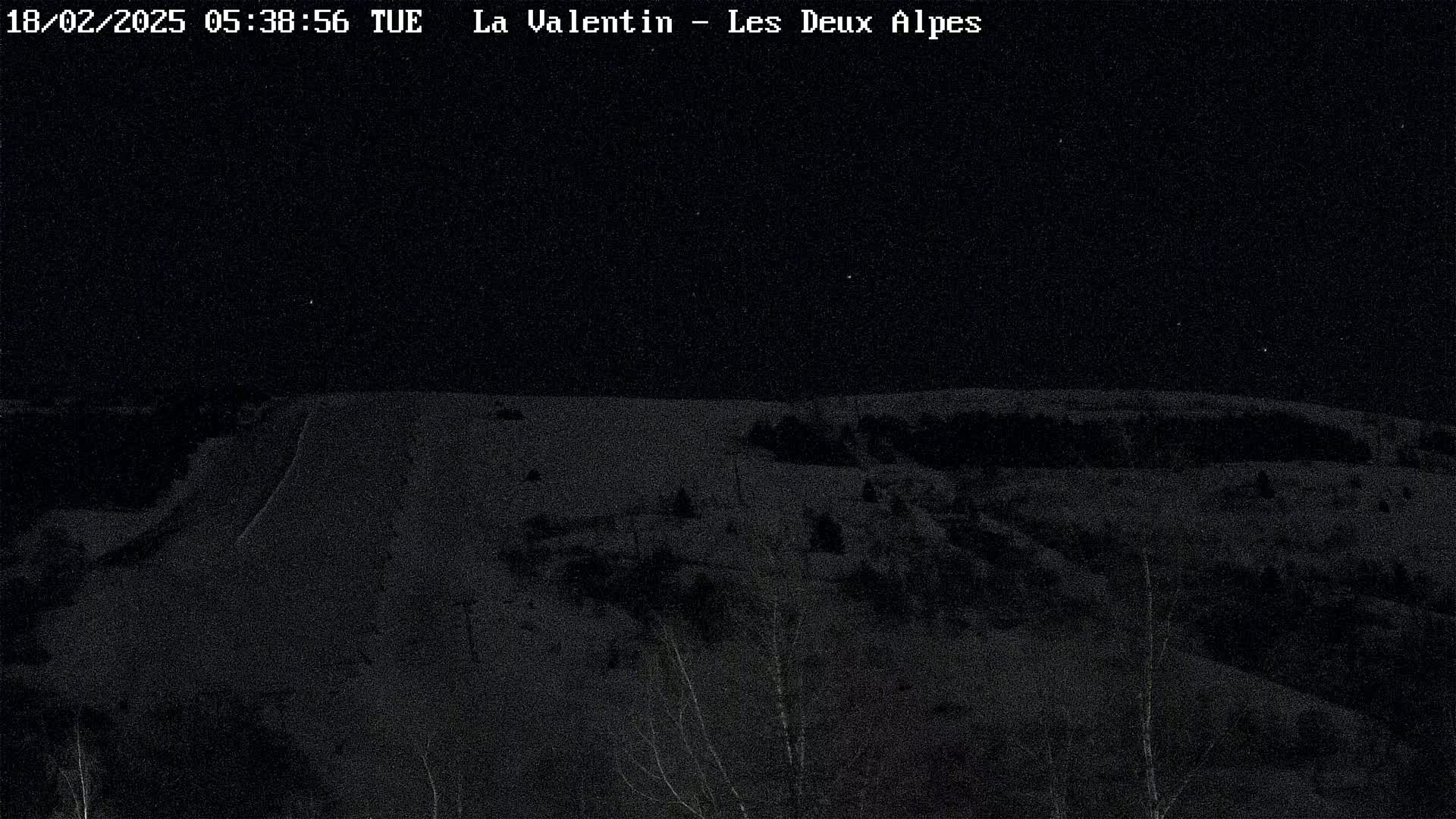 A nighttime, snow-covered landscape is visible under a clear, starry sky.
