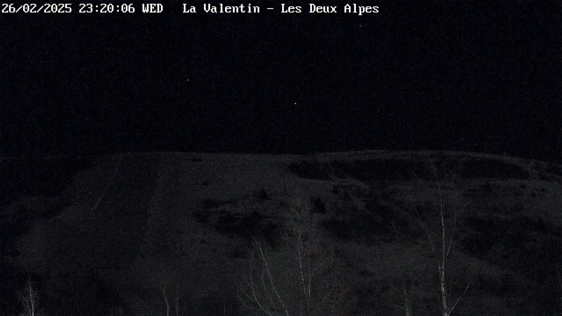 A nighttime, snow-covered landscape is visible under a clear, starlit sky.