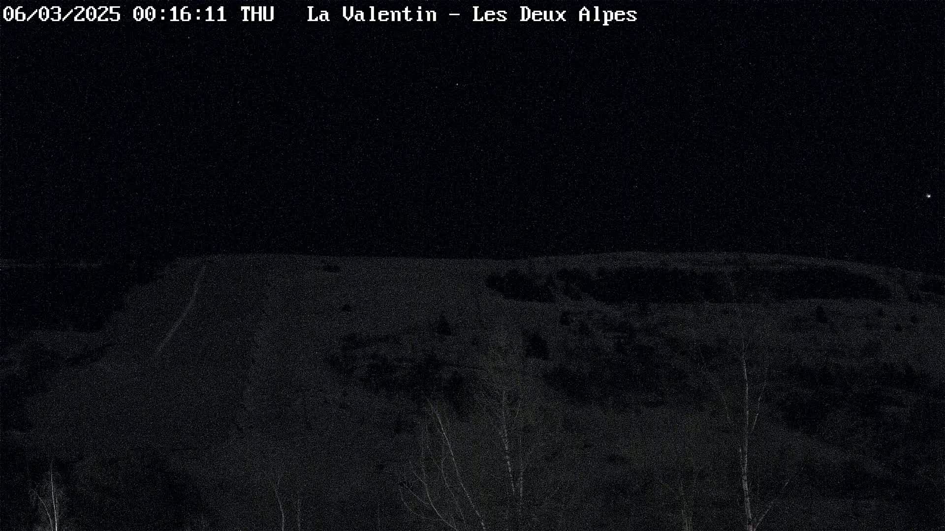 A nighttime, snow-covered landscape is visible under a clear, starry sky.