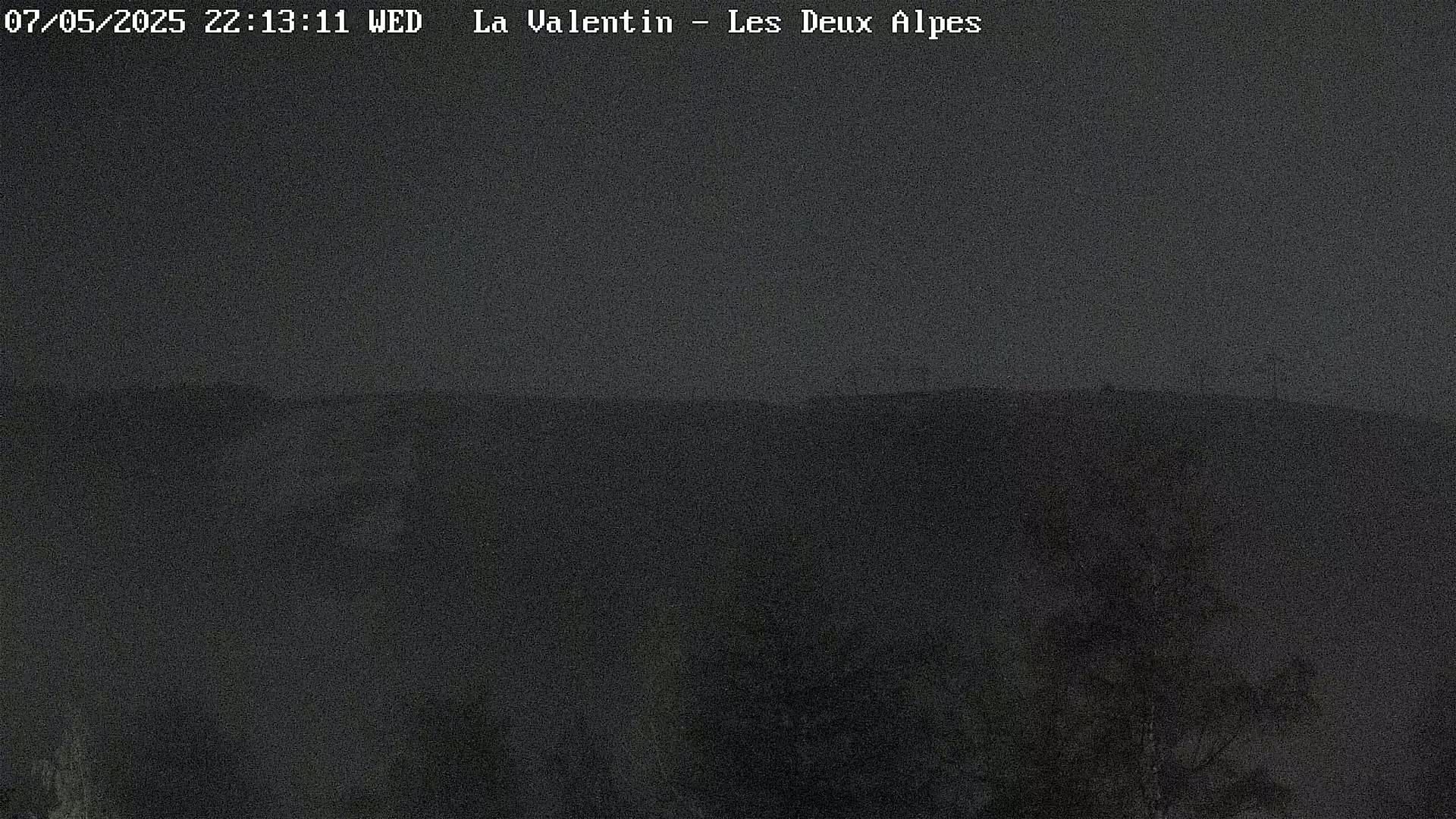 A dark, hazy view of a mountain landscape at night.