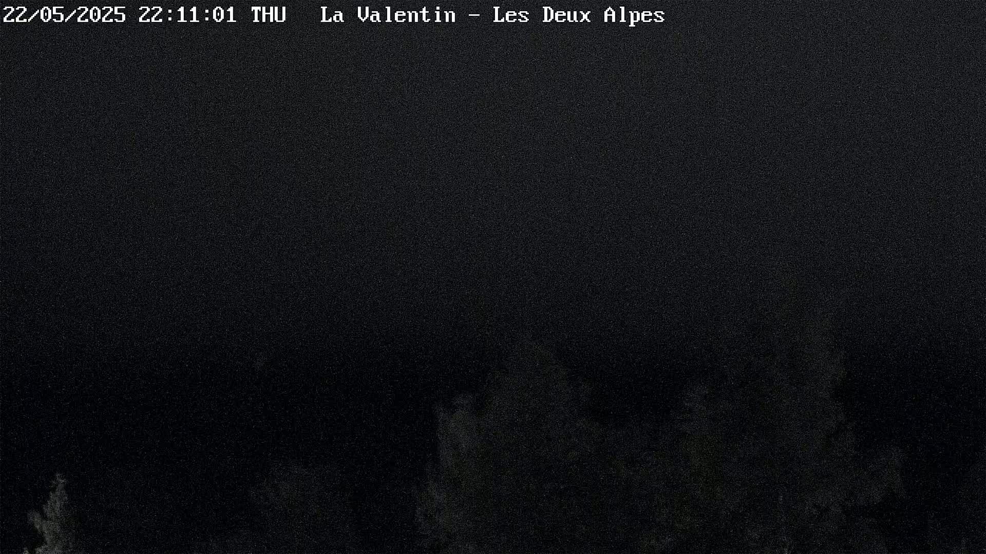 A dark, nighttime image shows a blurry, indistinct landscape under a dark sky.