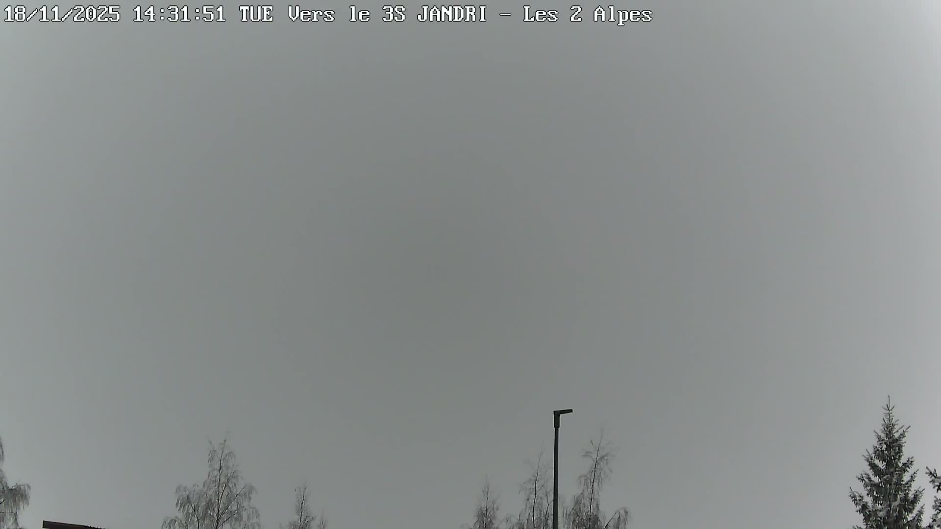 A clear blue sky overlooks a mountain slope with sparse vegetation and a cable car system.