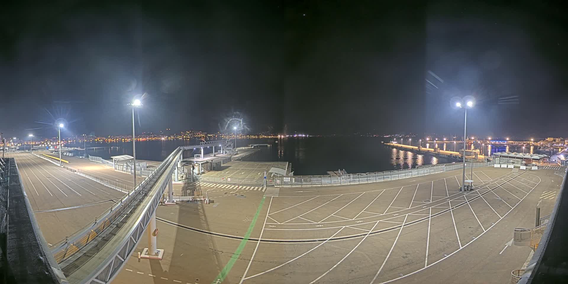The image presents a harbor scene with a large yellow ferry, a prominent white cruise ship, and a distant blue ferry docked by concrete piers and access ramps, all illuminated by a bright sun breaking through an otherwise overcast sky.